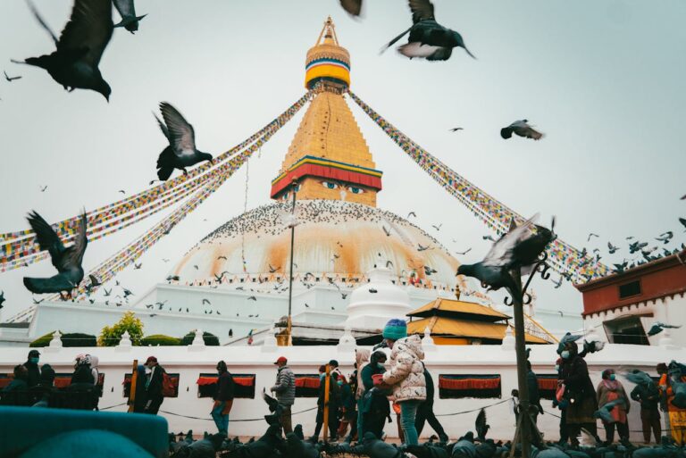 Vibrant scene of Boudhanath Stupa with pigeons in Kathmandu, Nepal.